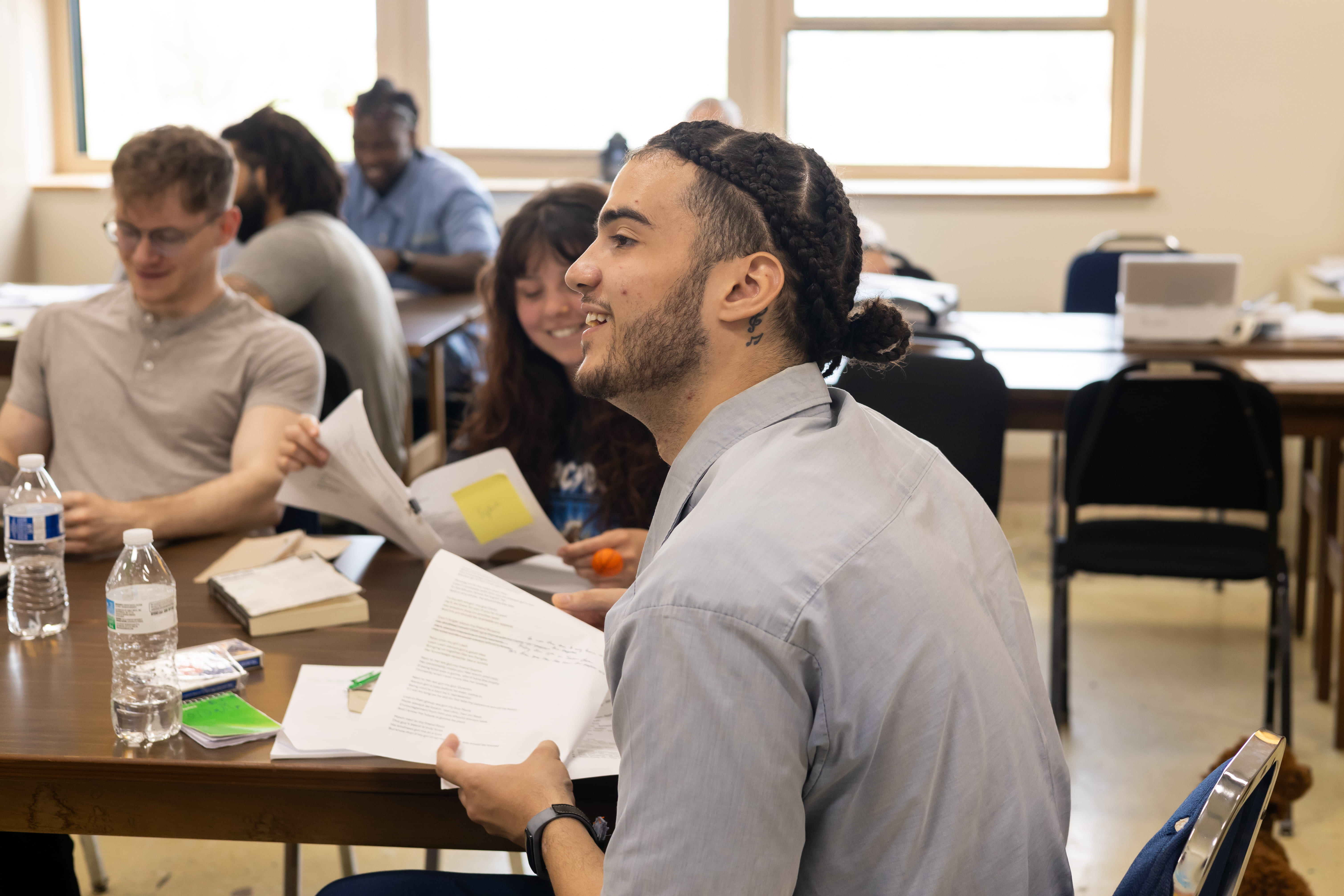 Incarcerated student Malik smiles while holding a reflection paper he wrote in Dr. Terrance Hinton's Spring 2024 Corrections class held at London Correctional Institution.