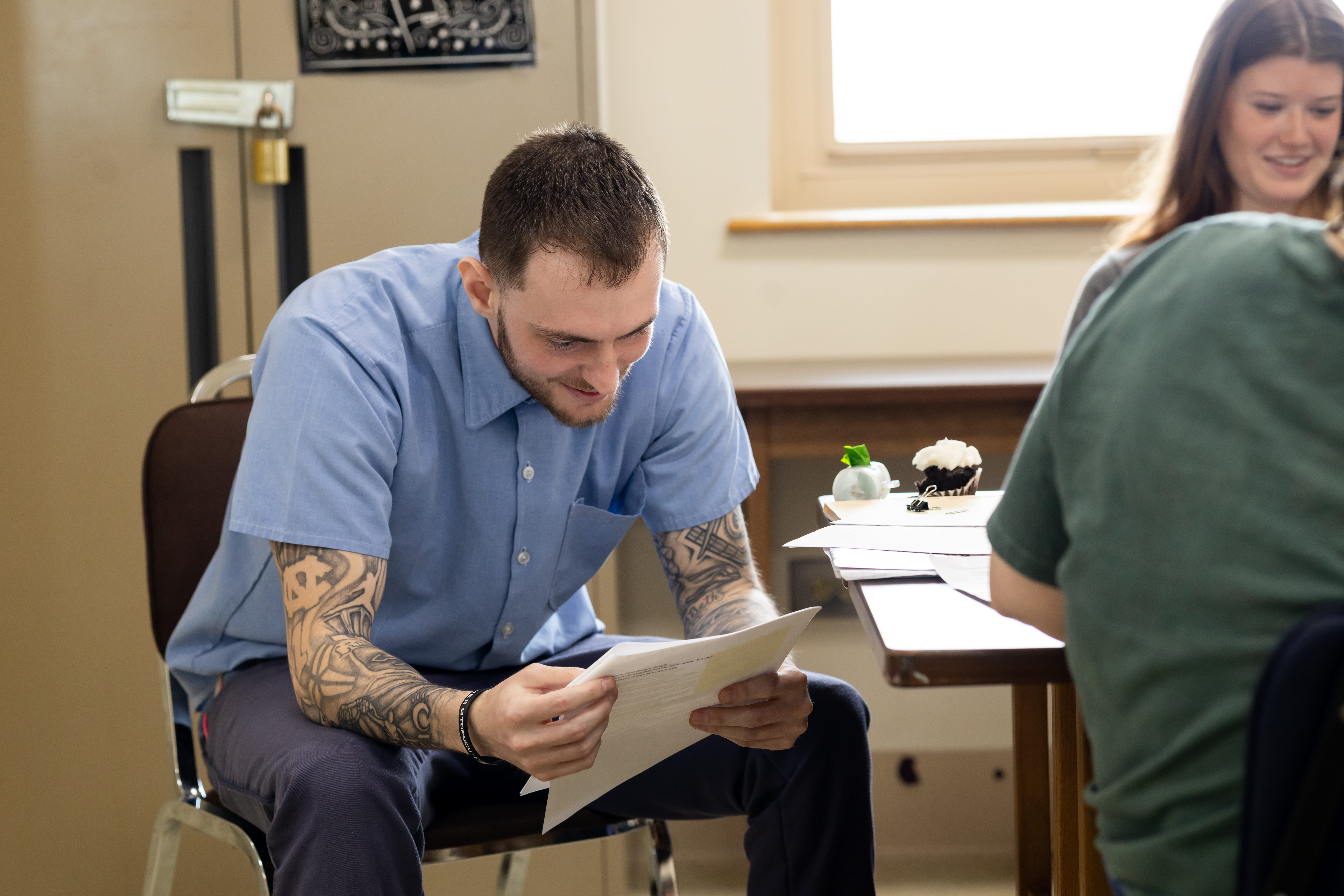 Incarcerated student Justin smiles while reading one of his peer's reflection essays and enjoying the celebratory activities on the final day of Dr. Terrance Hinton's Corrections class held at London Correctional Institution in Spring 2024.