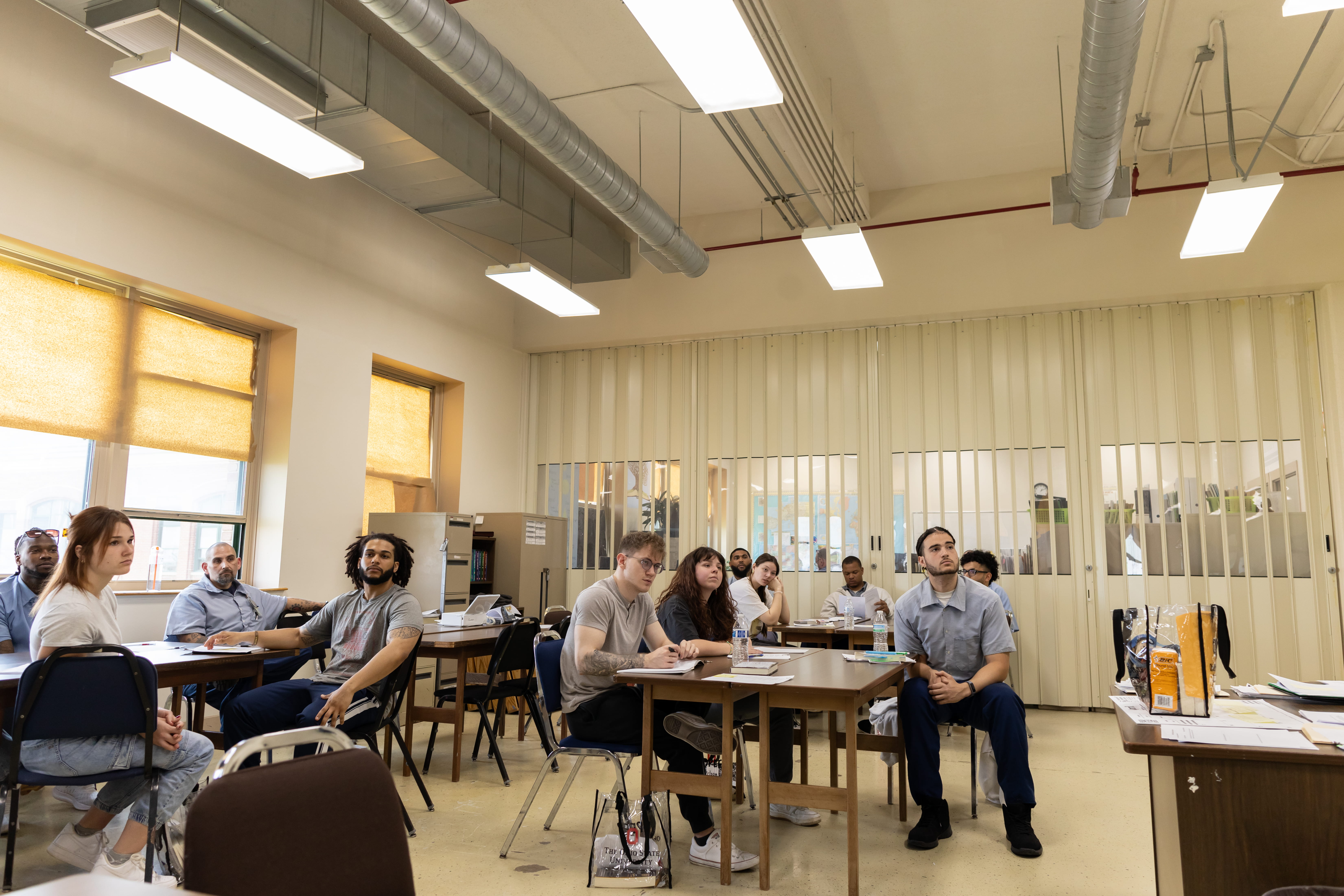 6 incarcerated students and 5 campus-based students look to the front of the room while listening to reflections from their peers on the final day of Dr. Terrance Hinton's Corrections class held at London Correctional Institution in Spring 2024.