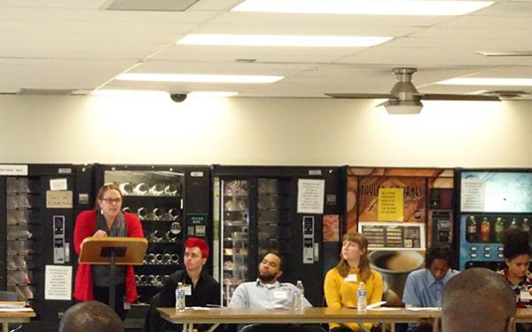 Instructor standing at podium talking to a group of students