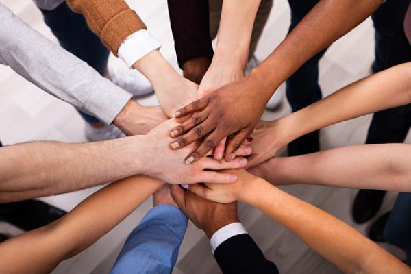 Group of diverse hands stacked together in unison