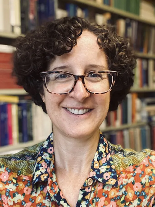 Amy Shuster in front of bookshelf