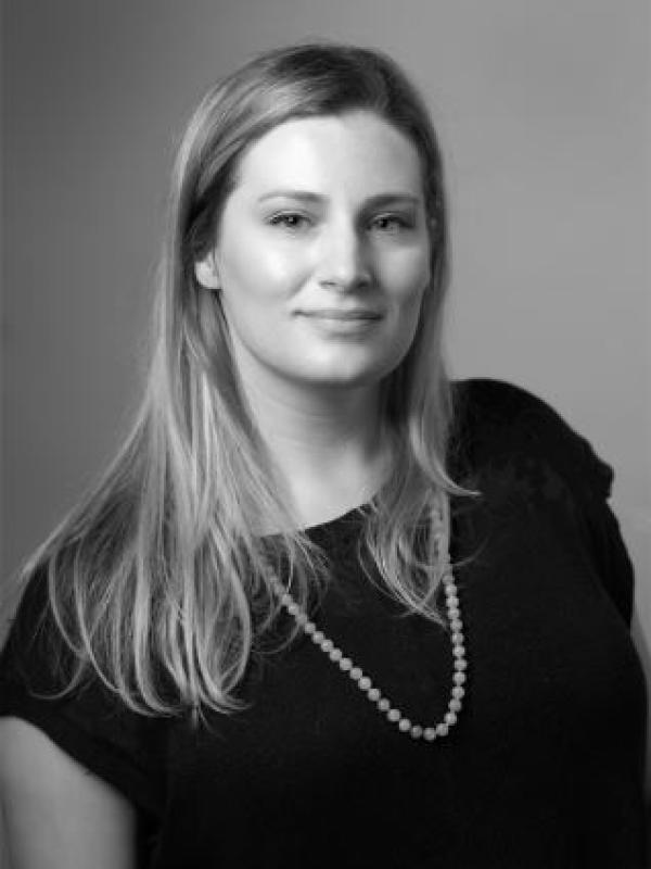 Black and white photo of blonde woman with necklace and black shirt