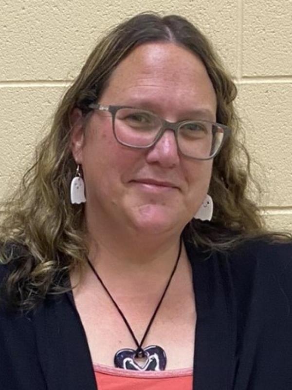 Blonde woman with gray glasses and white ghost earrings