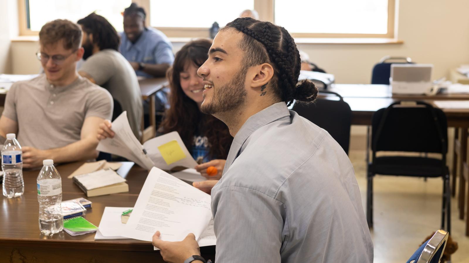 Incarcerated student Malik smiles while holding a reflection paper he wrote in Dr. Terrance Hinton's Spring 2024 Corrections class held at London Correctional Institution.